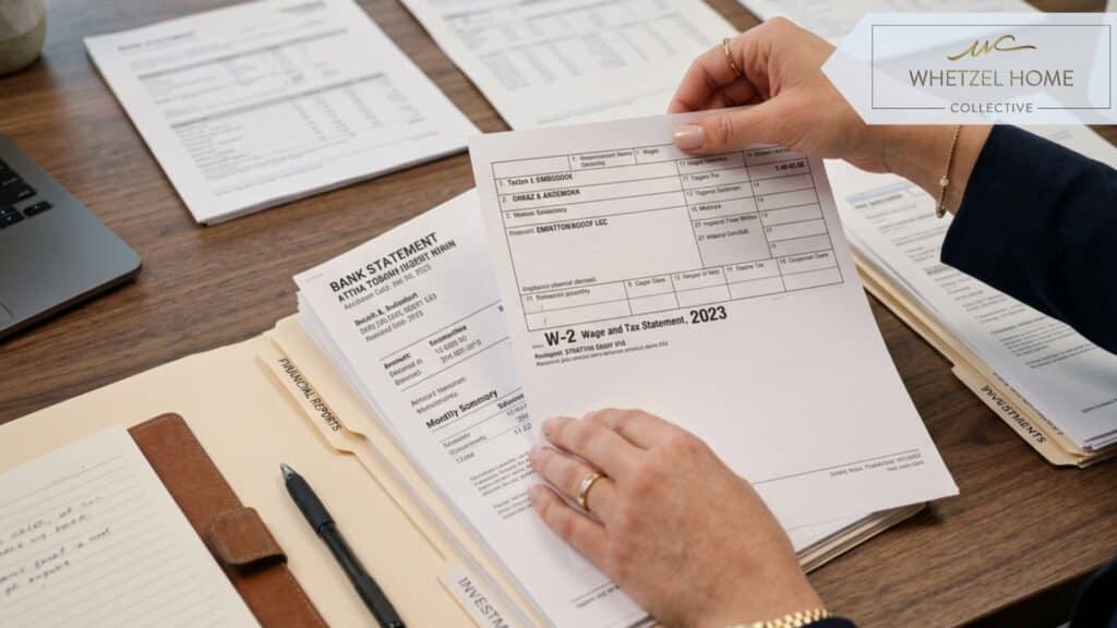 Close-up of hands organizing financial documents, W-2s, and bank statements on a sleek modern desk, warm morning light, photorealistic, shallow depth of field, professional corporate setting.