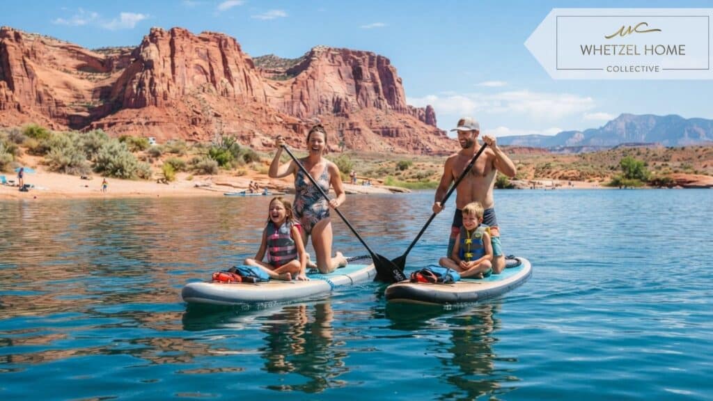A family enjoying outdoor lifestyle at a reservoir in Hurricane Utah, paddleboarding on bright blue water, majestic red sandstone cliffs reflecting in the water, vibrant sunny day, realistic lifestyle photography, joyful mood.